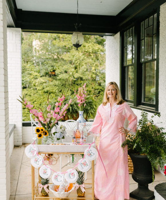 lydia menzies welcoming guests on her front porch with bar cart