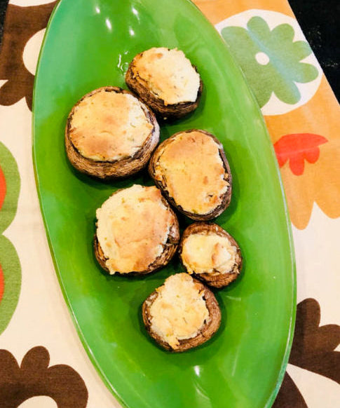 mushroom bites with cheese on top on a green plate