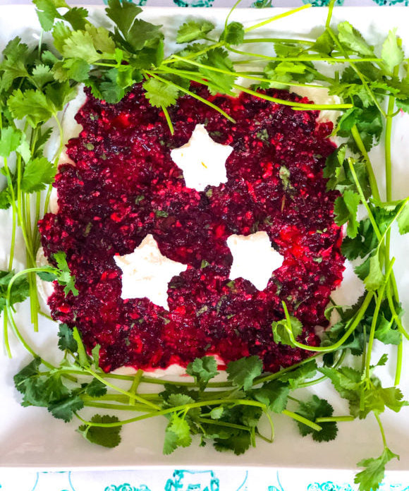 cranberry jalapeno dip with cream cheese stars and surrounded by cilantro