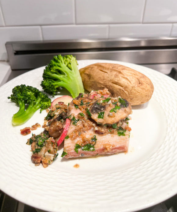 mahi mahi fish cooked in sherry cooking wine and served on a white plate with broccoli and a baked potato