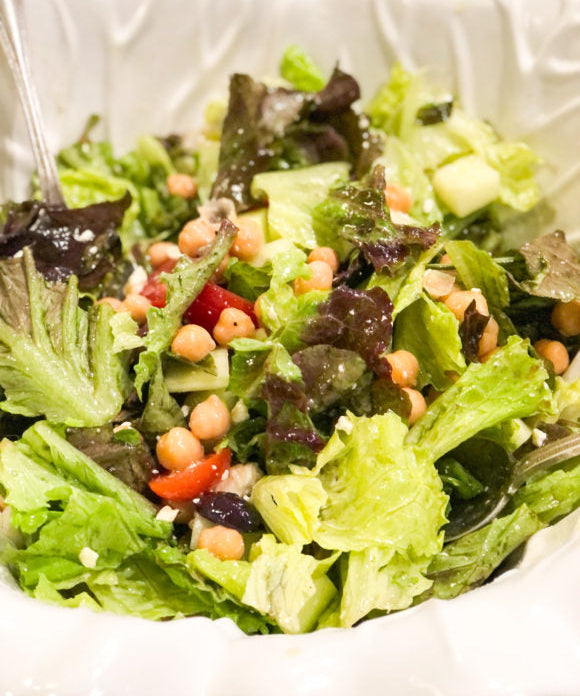 greek salad with chick peas in white salad bowl