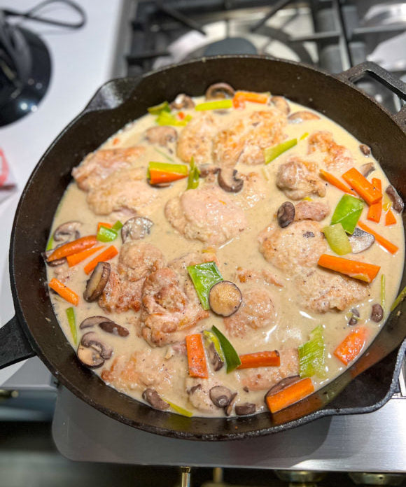 chicken in a mushroom cream sauce with carrots leeks and asparagus