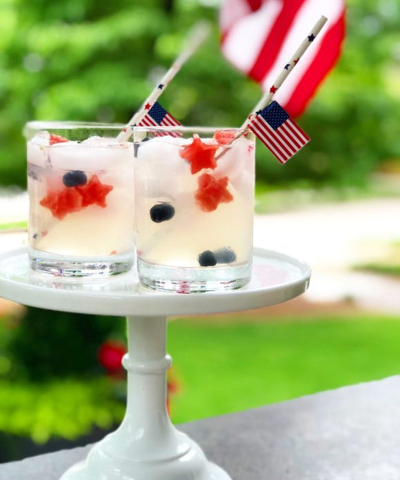 lemonade with blueberries and star shaped watermelon american flag and paper straw with stars on it