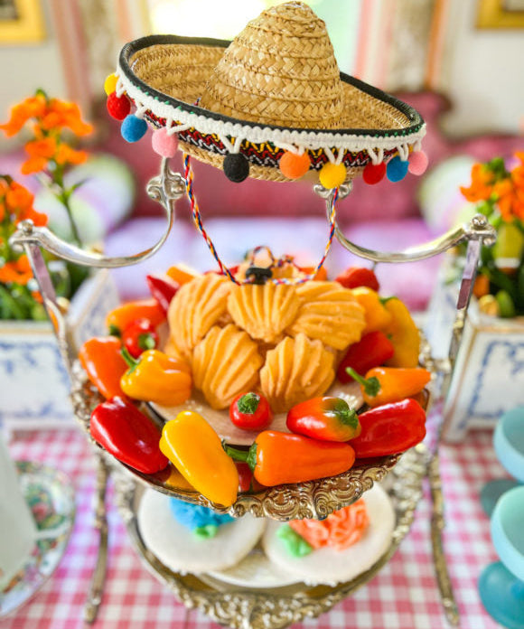 silver tiered tray with cheese wafers on top level and cookies on lower level with mini sombrero on top of serving piece