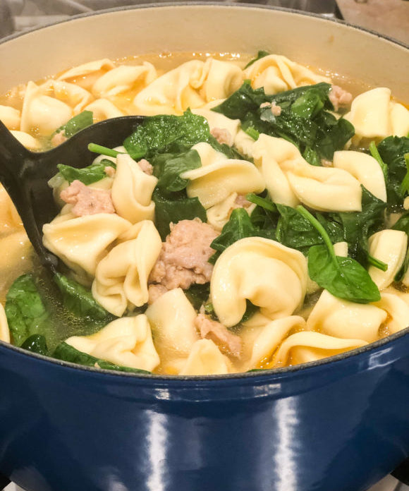 totellini soup with spinach and sausage in large blue pot