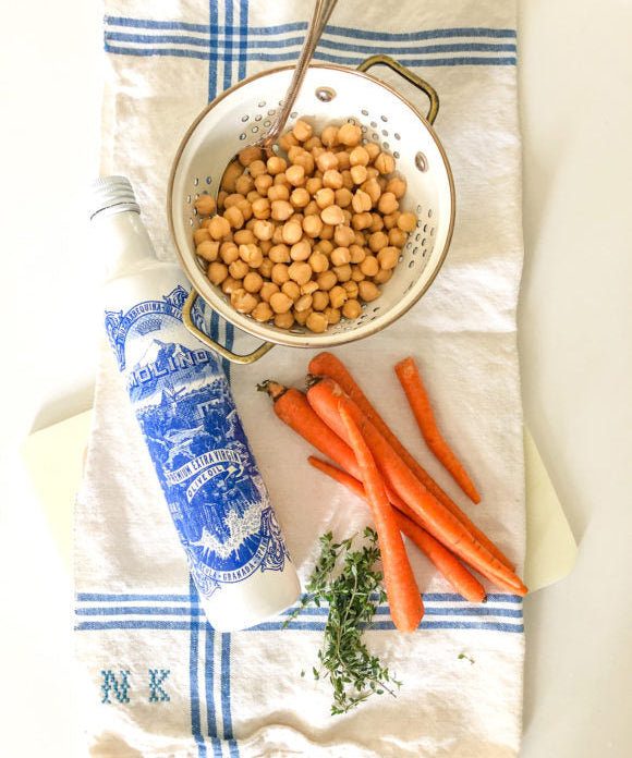carros on a kitchen towel chickpeas in a bowl olive oil in a blue and white bottle