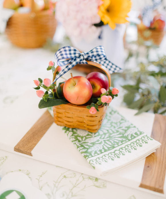 mini picnic basket filled with mini apples and greenery
