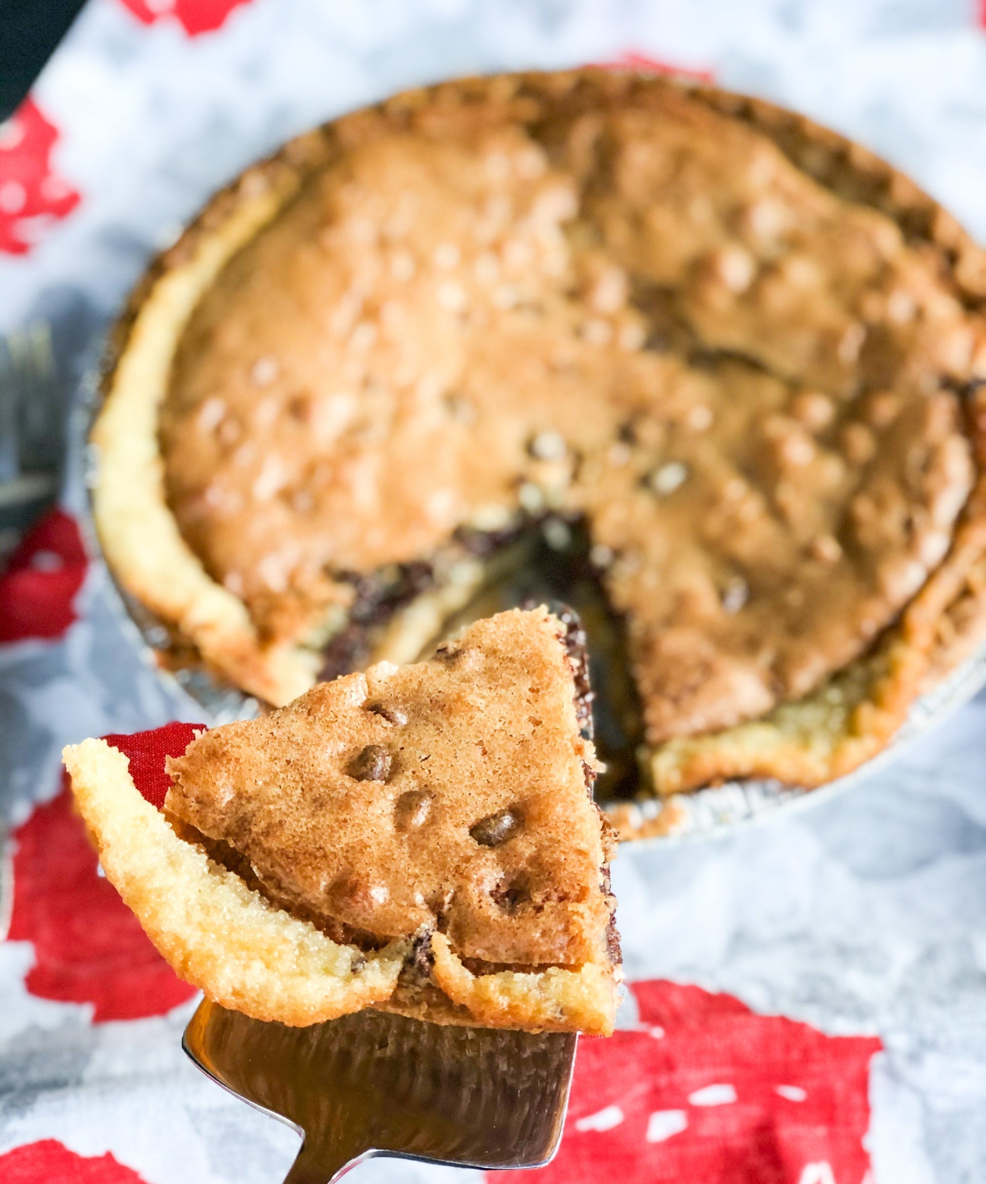 chocolate chip pie slice being lifted out of pie