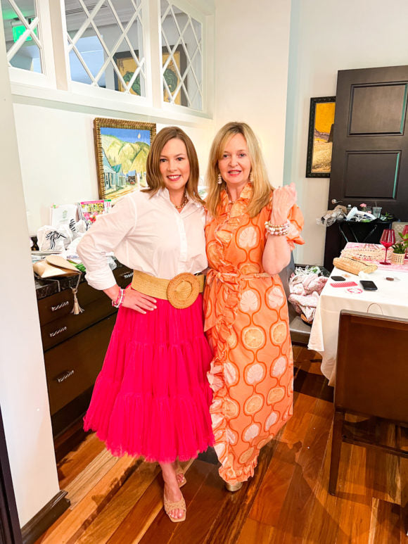 2 ladies in dresses showing bracelets on arm