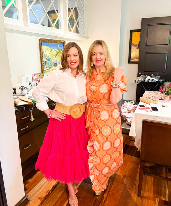 2 ladies in dresses showing bracelets on arm