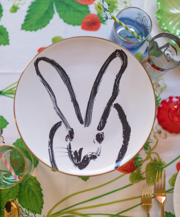black and white bunny plate on top of cake stand placed on strawberry themed fabric