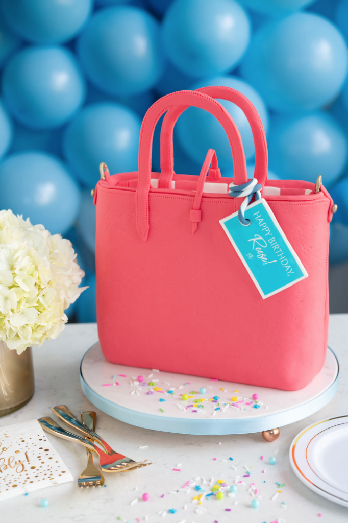 coral colored handbag sculpted cake with draper James tag on it for Reese Witherspoon's birthday