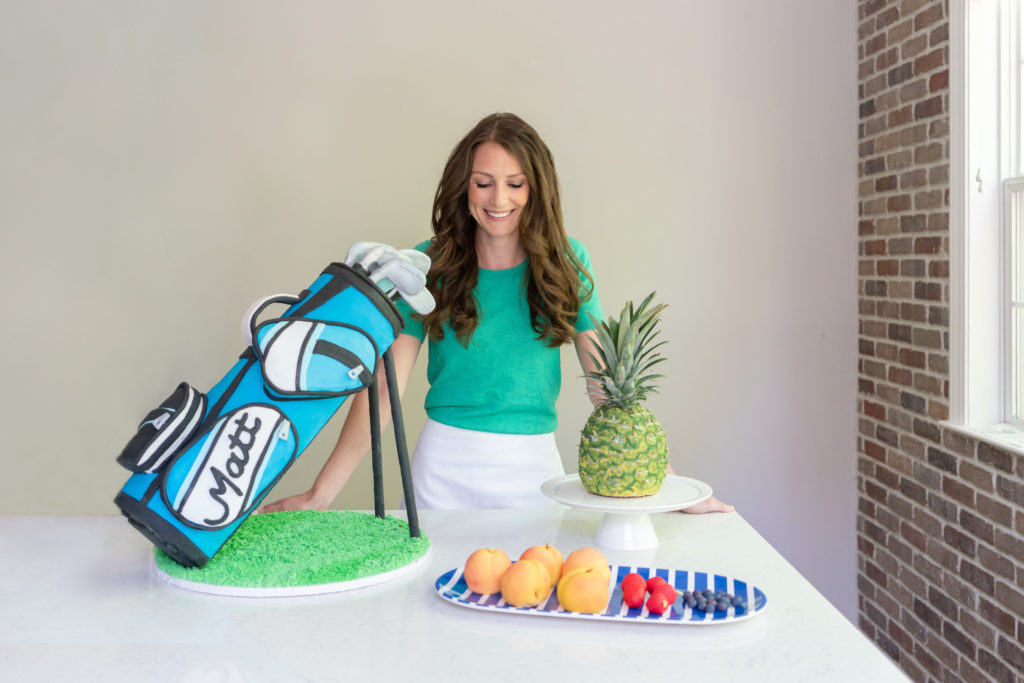 Julie McAllister of For Heaven Bakes Bakery with her sculpted golf bag cake