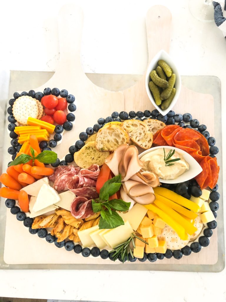 charcuterie board with food in shape of a whale outlined with blueberries