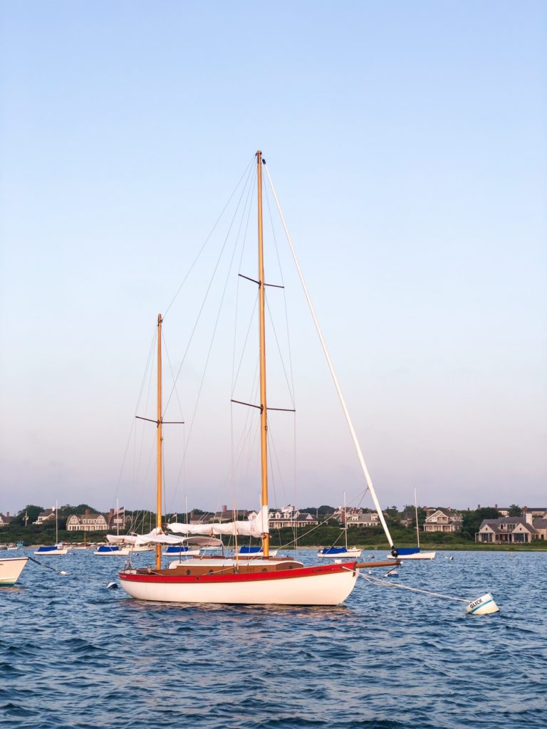 red and white nantucket sailboat without sails 
