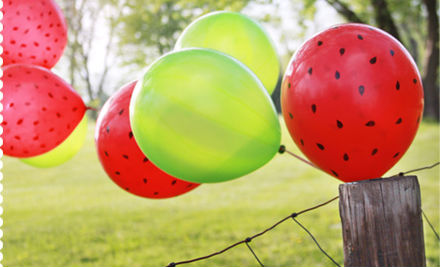 green balloons and red balloons with black seeds drawn on them to look like a bouquet of watermelon balloons