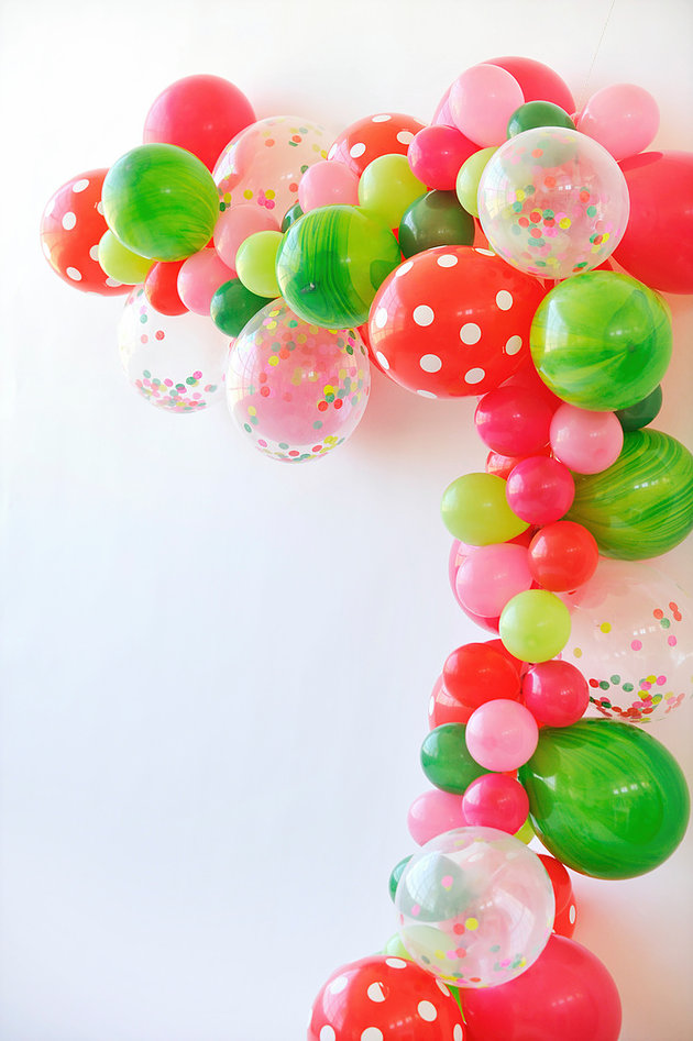red pink green clear balloons with confetti drape to make a balloon garland