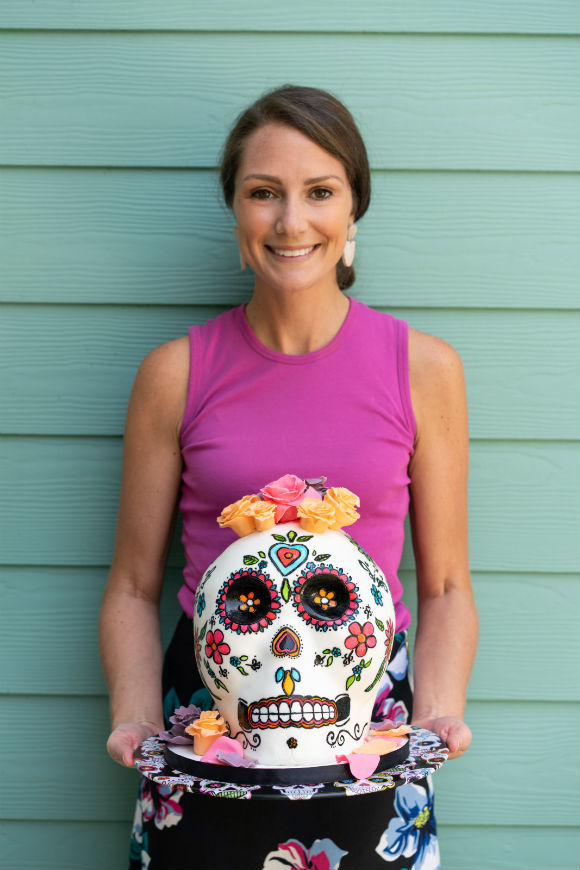 Lady in purple holding Day of the Dead Skull cake