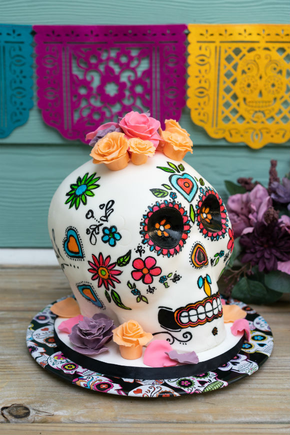 side view of day of dead skull cake handpainted with bright colors