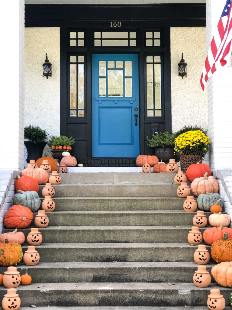 front porch halloween decorations with blue door and clay jack o lanterns