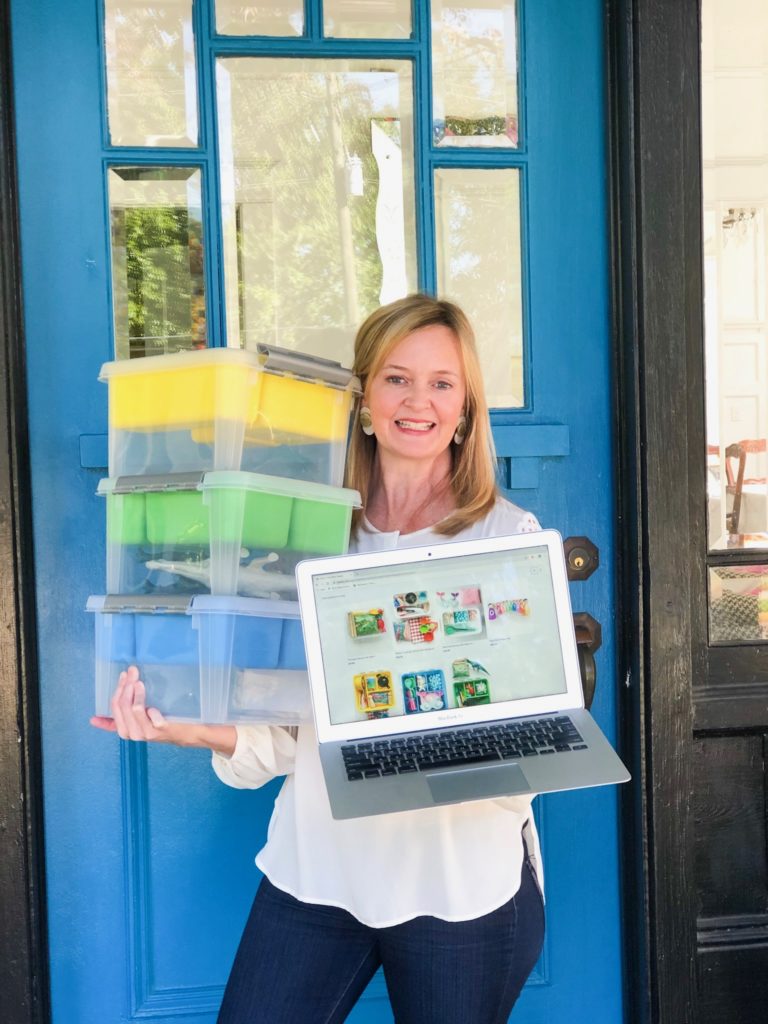 lady in front of blue door with computer and boxes introducing her square online store