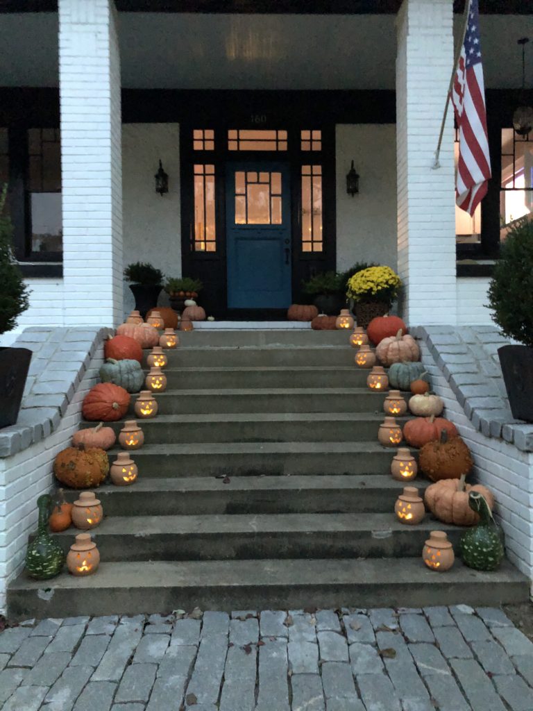 halloween front porch with jack o lanterns glowing on each step