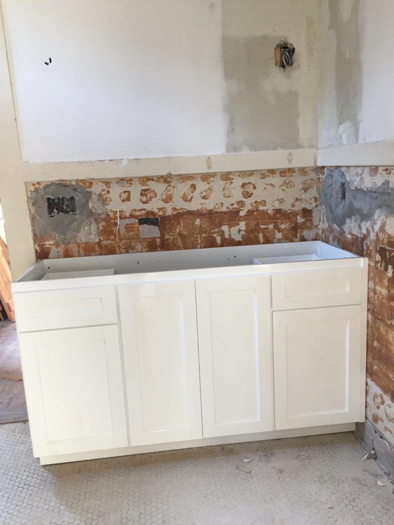 photo of new cabinet being put in an old bathroom during a remodel