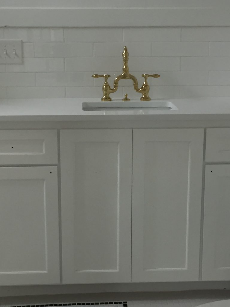 white cabinets with brass vintage hardware faucet