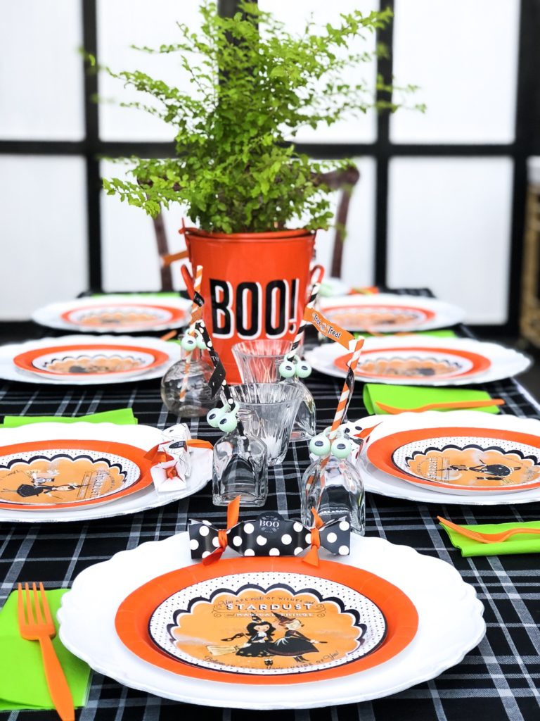 halloween party table setting with boo bucket with green plant inside