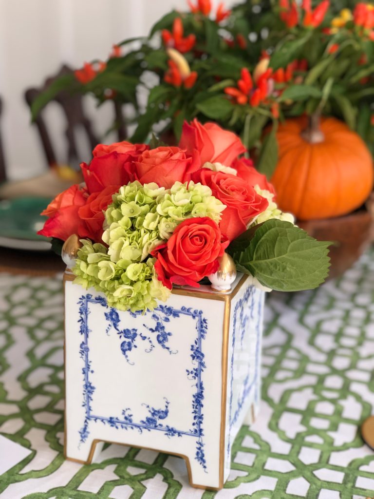 blue and white porcelain vase with orange roses and limelight hydrangeas