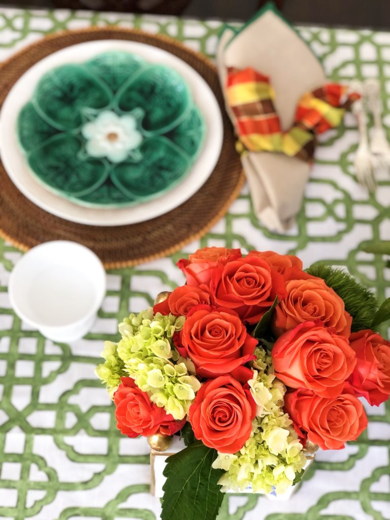 green majolica plates paired with orange roses and hydrangeas on thanksgiving table