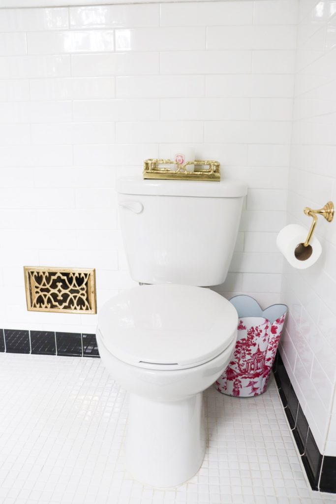 white bathroom toilet with brass