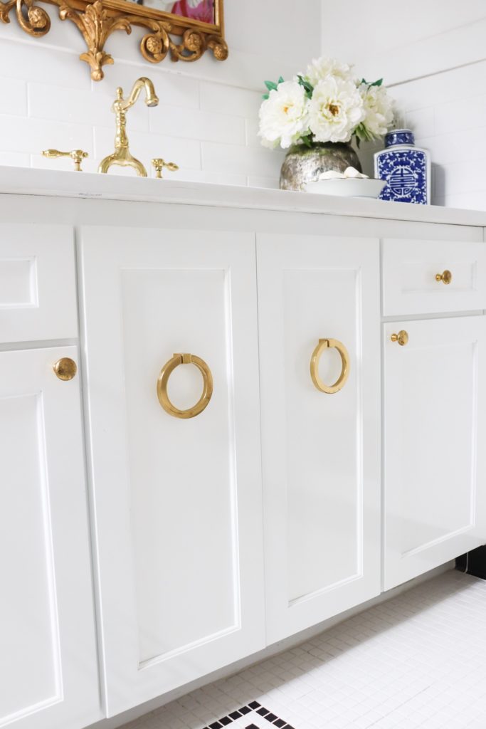White bathroom cabinets with large round brass hardware
