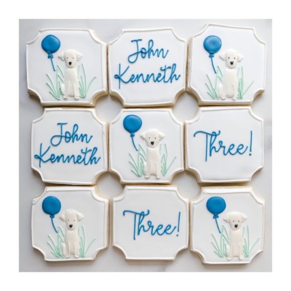 decorated cookies with golden retriever puppies and blue balloons on them