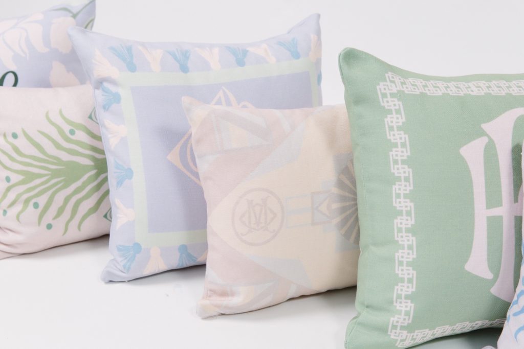 custom designed pillows in different patterns lined up on white floor and wall