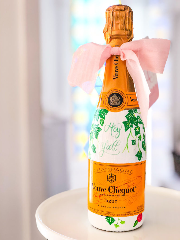 veuve champagne bottle painted white with ivy vine and camelias painted on it