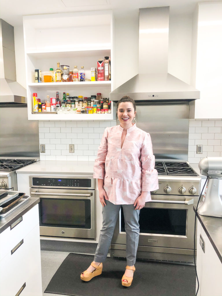 ivy odom in pink tiered shirt and gray pants in her southern living test kitchen
