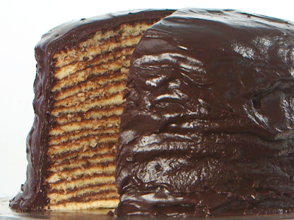 eighteen layer cake with chocolate frosting with slice cut out of it