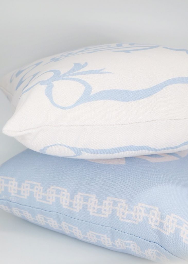 light blue square pillow with a white square pillow on top of it