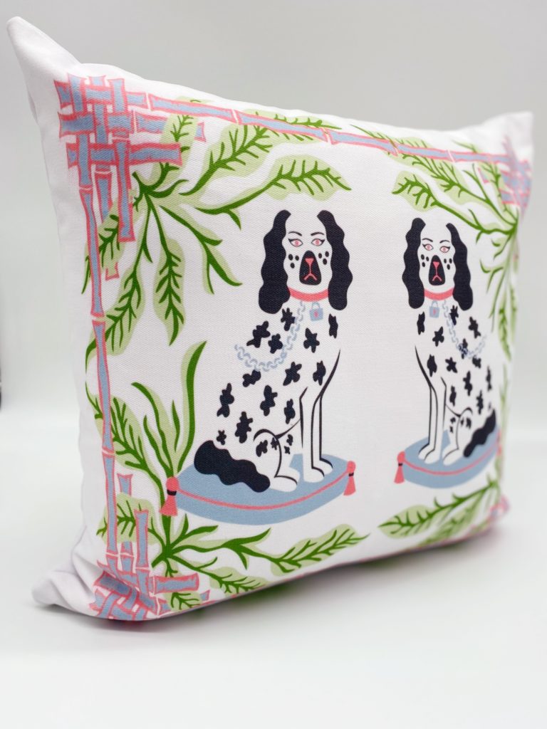 white pillow with black and white staffordshire pups with green palm leaves