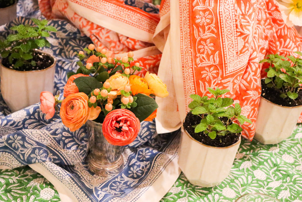 table linens in green blue and coral with mint plants and poppy flowers