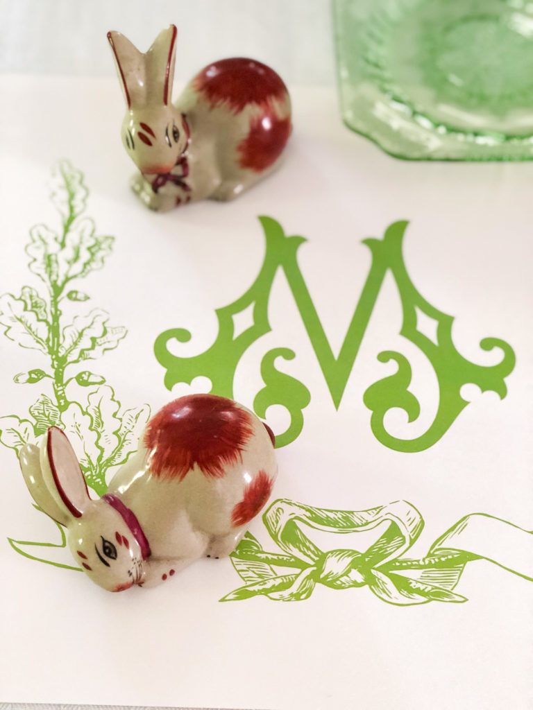 two porcelien bunnies on monogrammed placemat