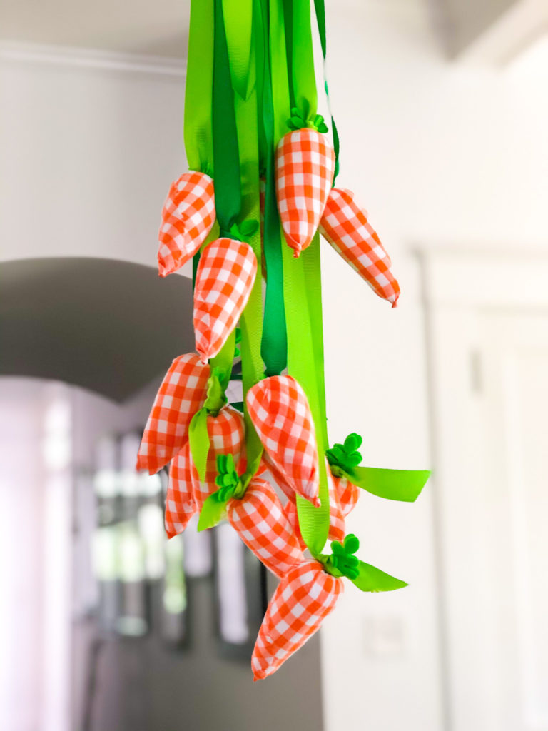 gingham fabric carrots on green ribbon hanging from a chandelier