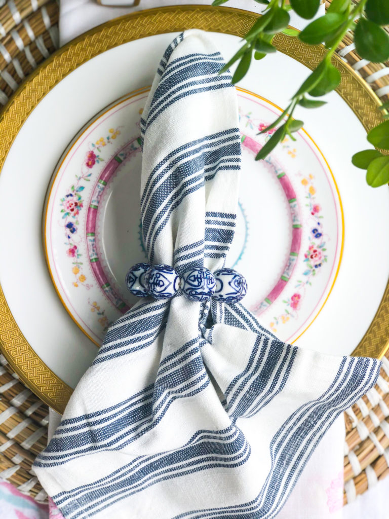 table set with two dishes and blue and white stripe napkin on top
