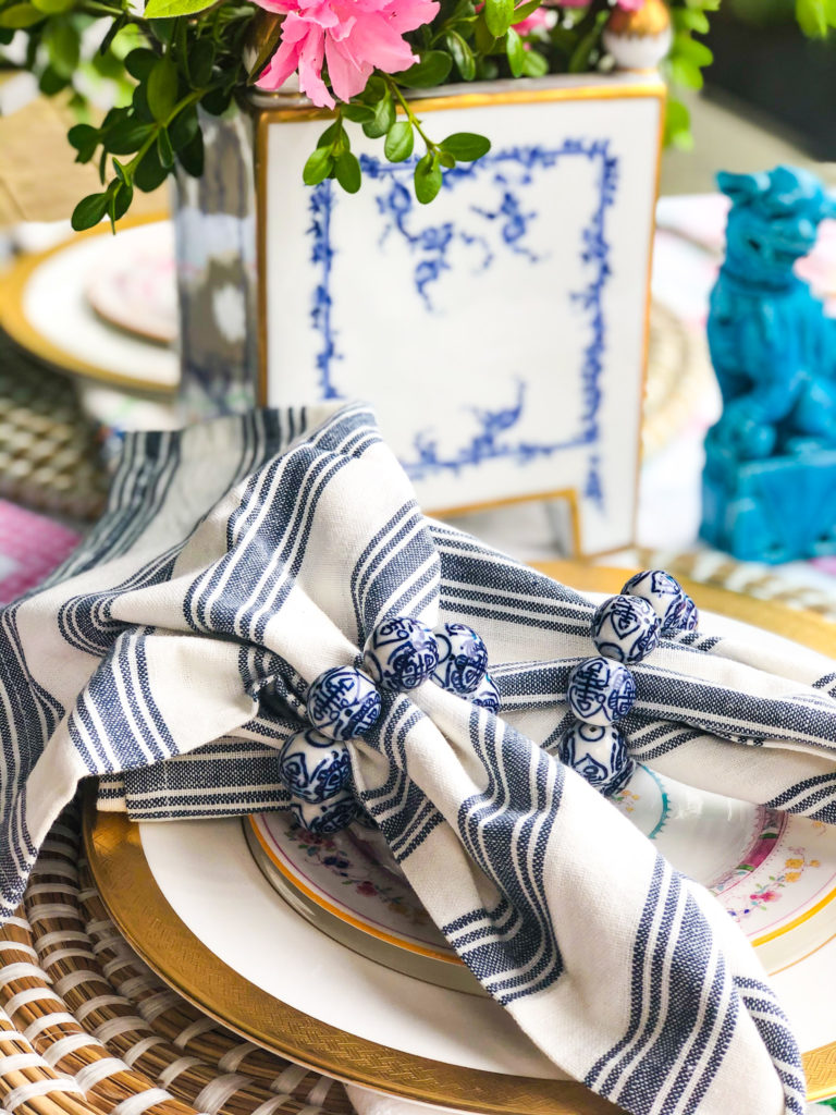 place setting with china and blue and white napkins with chinoiserie bead napkin rings