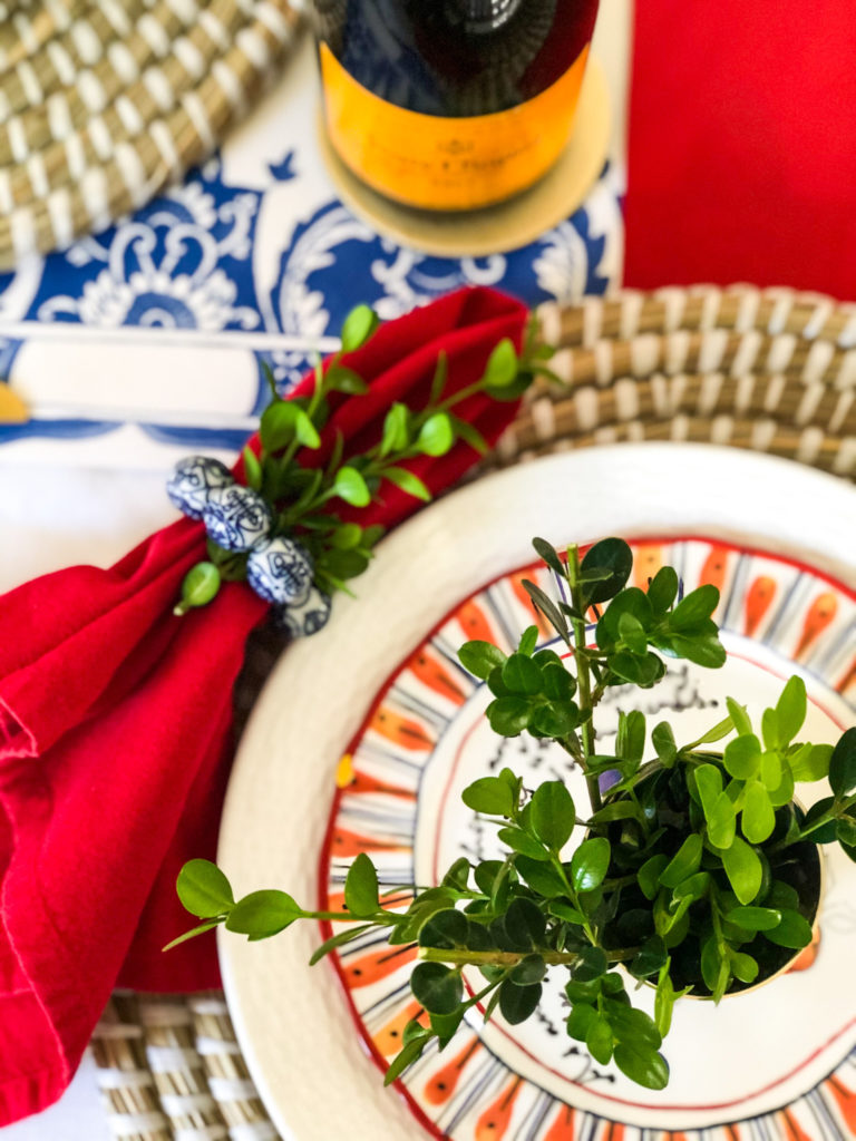 red white blue table setting with boxwood clippings in silver cup on plate