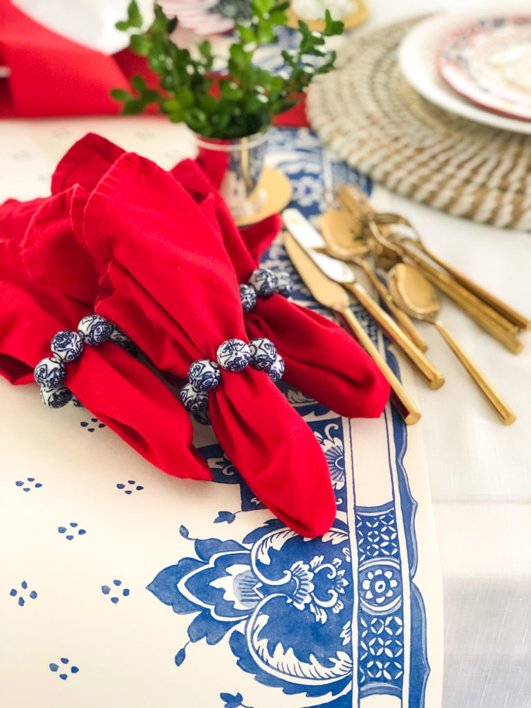 red napkins with blue and white chinoiserie napkin rings with gold forks