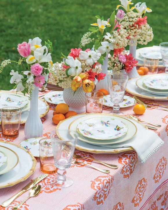 table setting with coral block print table cloth flowers in white hobnail vases and herend plates