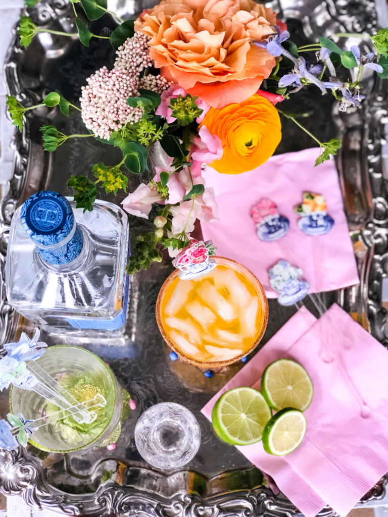 silver tray with gin orange soda lime slices and flowers