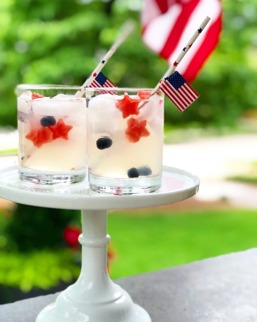lemonade with blueberries and star shaped watermelon american flag and paper straw with stars on it